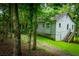 Charming home nestled in a wooded lot with green grass and mature trees at 1775 Whooping Creek Rd, Carrollton, GA 30116