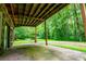 Covered patio with stone facade and views of the surrounding woods at 1775 Whooping Creek Rd, Carrollton, GA 30116