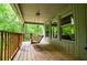 Relaxing covered porch with a wooden swing and views of the surrounding greenery at 1775 Whooping Creek Rd, Carrollton, GA 30116