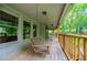 Inviting covered porch with a wooden swing, offering a relaxing outdoor space at 1775 Whooping Creek Rd, Carrollton, GA 30116