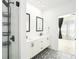 Modern bathroom featuring a double sink vanity, elegant patterned tile floor, and a sleek, glass-enclosed shower at 383 Pratt Se Dr # 503, Atlanta, GA 30315