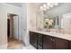 This bathroom features double sinks, a walk-in shower, tile flooring, and a door to the walk-in closet at 6918 Diamond Dr, Rex, GA 30273