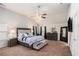 This primary bedroom features plush carpeting, a ceiling fan, a TV, and an ensuite bathroom at 6918 Diamond Dr, Rex, GA 30273