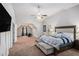 This primary bedroom features plush carpeting, a ceiling fan, a TV, a walk-in closet, and ensuite bathroom access at 6918 Diamond Dr, Rex, GA 30273