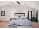 This primary bedroom features plush carpeting, a ceiling fan, an ensuite bathroom, and backyard views at 6918 Diamond Dr, Rex, GA 30273