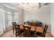 Dining room with wooden table and chairs beneath decorative lighting, featuring bar and bay window at 6918 Diamond Dr, Rex, GA 30273