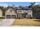 Charming two-story home featuring a well-manicured front lawn and attached garage at 6918 Diamond Dr, Rex, GA 30273