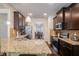 Granite countertop kitchen features dark wood cabinets and stainless steel appliances at 6918 Diamond Dr, Rex, GA 30273