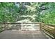 Exterior back deck with wooden rails overlooking mature trees and nature at 1107 Leslie Pl, Lithonia, GA 30058