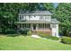 Charming two-story home featuring a covered front porch and lush landscaping at 1107 Leslie Pl, Lithonia, GA 30058