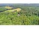 A view of lush greenery with a house visible in the distance surrounded by trees and open space at 12550 Hutcheson Ferry Rd, Palmetto, GA 30268