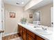 Bathroom features a double sink vanity with wood cabinets and framed mirror at 12550 Hutcheson Ferry Rd, Palmetto, GA 30268