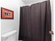 Bathroom featuring a toilet and a dark shower curtain and a framed picture at 12550 Hutcheson Ferry Rd, Palmetto, GA 30268