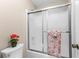 Bathroom showcasing tiled shower with sliding glass doors at 12550 Hutcheson Ferry Rd, Palmetto, GA 30268