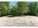 View of a concrete driveway leading to a home surrounded by mature trees and a grassy lawn at 12550 Hutcheson Ferry Rd, Palmetto, GA 30268