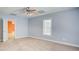 Neutrally decorated bedroom featuring neutral carpeting, window, and an adjacent doorway at 155 Skyview Dr, Social Circle, GA 30025