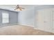 Spacious bedroom featuring neutral carpeting, soft blue walls, and ceiling fan with lighting at 155 Skyview Dr, Social Circle, GA 30025