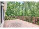 Wooden deck overlooking a backyard filled with lush greenery and mature trees at 155 Skyview Dr, Social Circle, GA 30025