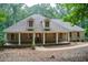 Charming brick home featuring a welcoming front porch with stately columns and a well-maintained lawn at 155 Skyview Dr, Social Circle, GA 30025