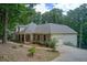 Side view of a home with a sprawling porch, two-car garage, and meticulous landscaping at 155 Skyview Dr, Social Circle, GA 30025