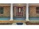 Up close front porch view shows an ornate front door, classic columns, and brick detailing at 155 Skyview Dr, Social Circle, GA 30025