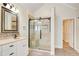 Luxurious main bathroom featuring a tiled shower with a glass door, vanity, and linen storage at 155 Skyview Dr, Social Circle, GA 30025