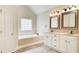 Relaxing main bathroom showcasing a soaking tub, dual vanities, and modern fixtures at 155 Skyview Dr, Social Circle, GA 30025