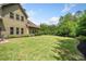 Large grassy backyard with a house featuring vinyl siding on the left and lovely landscaping on the right at 390 Scott Farm Dr, Powder Springs, GA 30127