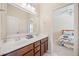 Bathroom featuring double sinks, a mirror and a doorway leading to the bedroom at 390 Scott Farm Dr, Powder Springs, GA 30127