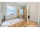 Bathroom featuring soaking tub, window, and separate shower with glass door at 390 Scott Farm Dr, Powder Springs, GA 30127
