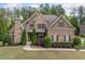 Beautiful brick home with manicured landscaping, a stone chimney, and a welcoming front porch at 390 Scott Farm Dr, Powder Springs, GA 30127