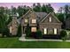 Elegant brick home with manicured landscaping and a stone chimney at 390 Scott Farm Dr, Powder Springs, GA 30127