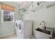 A well-organized laundry room featuring a sink, washer, dryer, and shelving at 390 Scott Farm Dr, Powder Springs, GA 30127