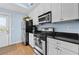 Modern kitchen featuring white cabinetry, stainless steel appliances, and black countertops, creating a sleek and functional space at 818 Virgil Ne St, Atlanta, GA 30307