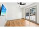 Bright bedroom with hardwood floors, ceiling fan, and large window providing ample natural light at 8671 Lake Forrest Dr, Douglasville, GA 30134