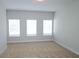 Bright bedroom featuring neutral carpet, three windows providing natural light, and neutral paint at 2163 Wiggins Walk, Atlanta, GA 30316