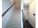 Carpeted staircase with wooden railing, leading to a bright, modern entryway with built-in storage at 2163 Wiggins Walk, Atlanta, GA 30316