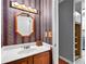 Cozy powder room featuring wood vanity, decorative mirror, and colorful wall paper at 2197 Spring Walk Ct, Atlanta, GA 30341