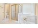 Bathroom featuring a soaking tub with gold fixtures and a glass enclosed shower at 1290 Mount Mckinley Dr, Grayson, GA 30017