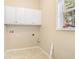 The laundry room has neutral walls and floors, white cabinets for storage, and a window at 1290 Mount Mckinley Dr, Grayson, GA 30017