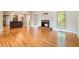 Open concept living room with hardwood flooring and a brick fireplace, seamlessly connecting to the kitchen at 1290 Mount Mckinley Dr, Grayson, GA 30017