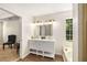 Bathroom featuring a double vanity, modern lighting, and a soaking tub under a window at 7167 Stonebrook Ln, Lithonia, GA 30058