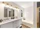 Bright bathroom with double vanity, a large mirror, and a tiled soaking tub at 7167 Stonebrook Ln, Lithonia, GA 30058