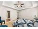 Spacious bedroom with neutral carpet, tray ceiling, and views into the connected bathroom at 7167 Stonebrook Ln, Lithonia, GA 30058
