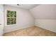 Bright bedroom featuring carpet flooring, an attic ceiling, and a window with a backyard view at 7167 Stonebrook Ln, Lithonia, GA 30058