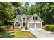 Charming home with a two-car garage, a dark roof, and situated on a wooded lot at 7167 Stonebrook Ln, Lithonia, GA 30058