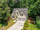 Angle view of a two-story home with a dark roof and attached two-car garage on a wooded lot at 7167 Stonebrook Ln, Lithonia, GA 30058