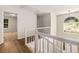 Upstairs hallway with wood floors, white railings, and natural light from a large window at 7167 Stonebrook Ln, Lithonia, GA 30058