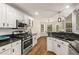 Bright kitchen with white cabinets, granite countertops, and stainless steel appliances at 7167 Stonebrook Ln, Lithonia, GA 30058