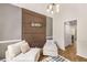 Bright living room with wood accent wall, modern chandelier, and comfortable seating at 7167 Stonebrook Ln, Lithonia, GA 30058